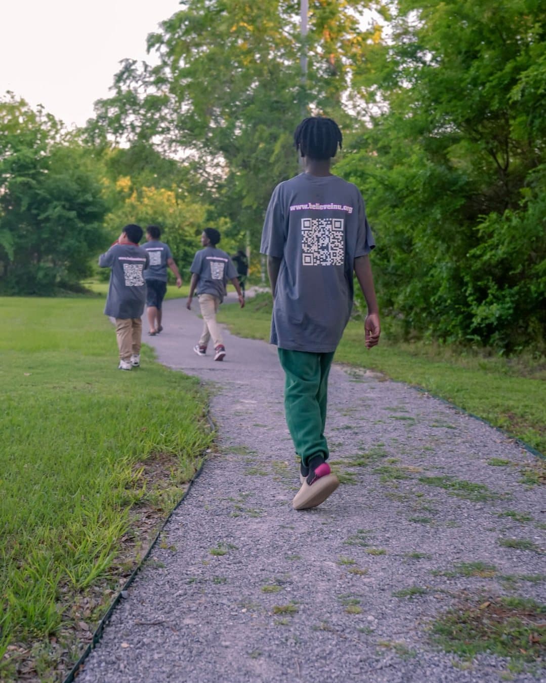 A camper walking a wooded trail ahead of the group
